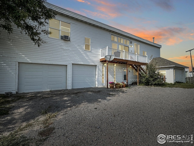 exterior space with a wooden deck, stairs, an attached garage, and cooling unit