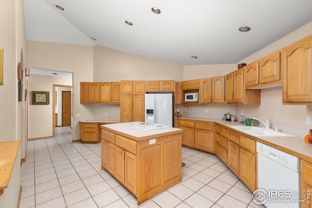 kitchen featuring vaulted ceiling, a center island, white appliances, and sink