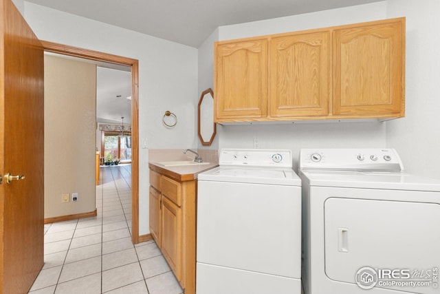 laundry area with cabinets, light tile patterned floors, washing machine and dryer, and sink