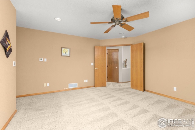 spare room featuring light carpet and ceiling fan