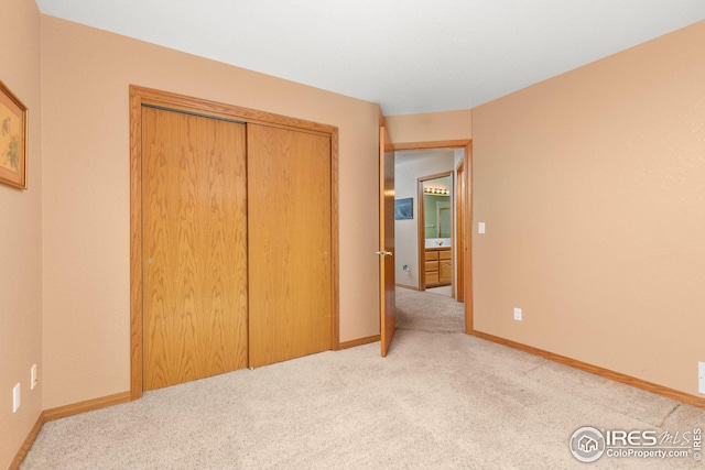 unfurnished bedroom featuring light colored carpet and a closet