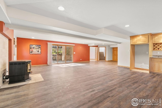 unfurnished living room with hardwood / wood-style flooring and a wood stove