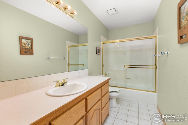 full bathroom with tile patterned floors, vanity, toilet, and enclosed tub / shower combo