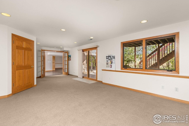 unfurnished room with carpet and french doors