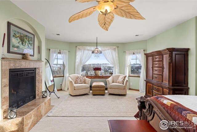 bedroom with ceiling fan, light colored carpet, and a textured ceiling