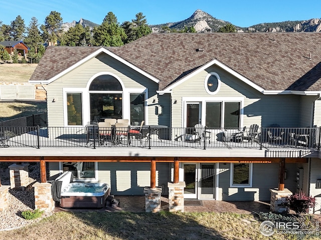 rear view of house featuring a deck with mountain view