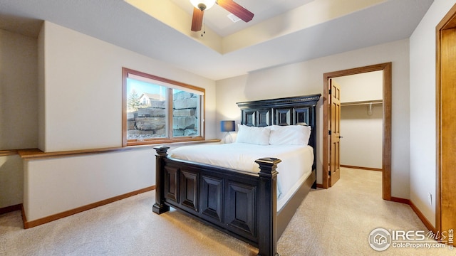 carpeted bedroom featuring a closet, ceiling fan, and a walk in closet