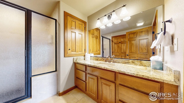 bathroom with vanity, tile patterned flooring, and a shower with door