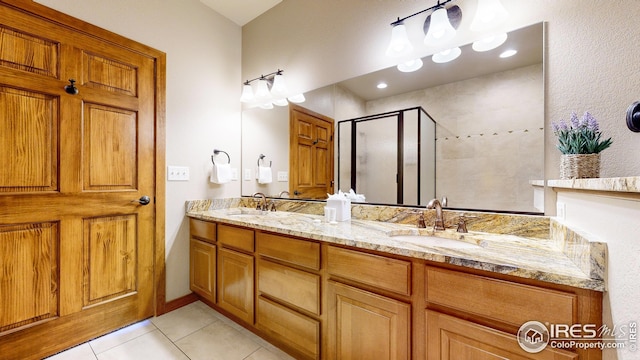 bathroom with walk in shower, vanity, and tile patterned floors