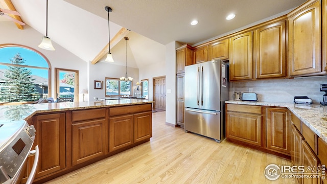 kitchen with light hardwood / wood-style floors, hanging light fixtures, decorative backsplash, appliances with stainless steel finishes, and light stone countertops