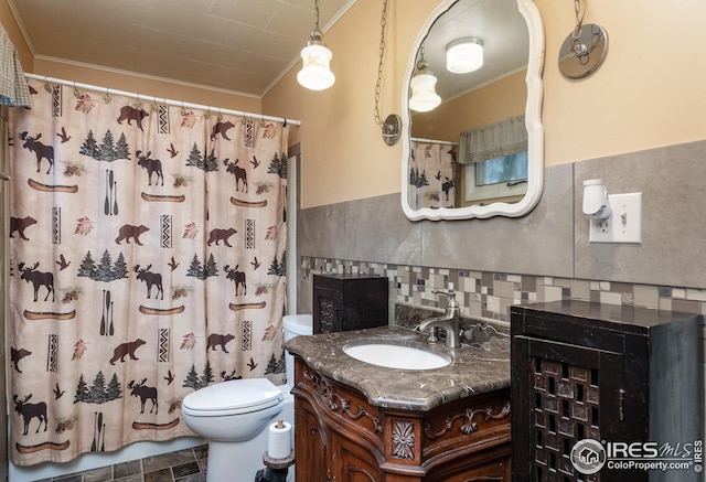 bathroom featuring tile walls, curtained shower, toilet, ornamental molding, and vanity