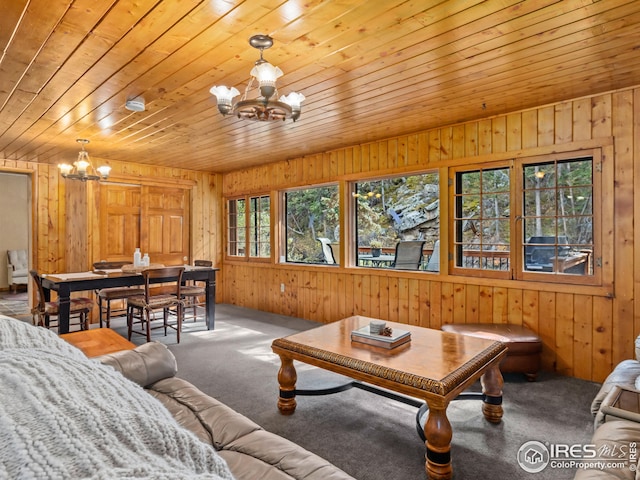 living area with carpet floors, an inviting chandelier, wooden ceiling, and wood walls