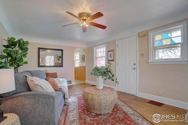 carpeted living room with baseboard heating and wooden walls