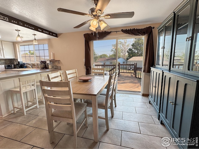 dining area with light tile patterned flooring, ceiling fan, and a textured ceiling