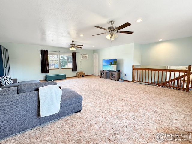 living room featuring a wall mounted air conditioner, carpet flooring, a textured ceiling, and ceiling fan