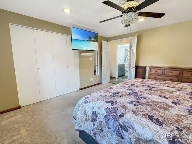 bedroom featuring ceiling fan, a closet, light carpet, and ensuite bathroom