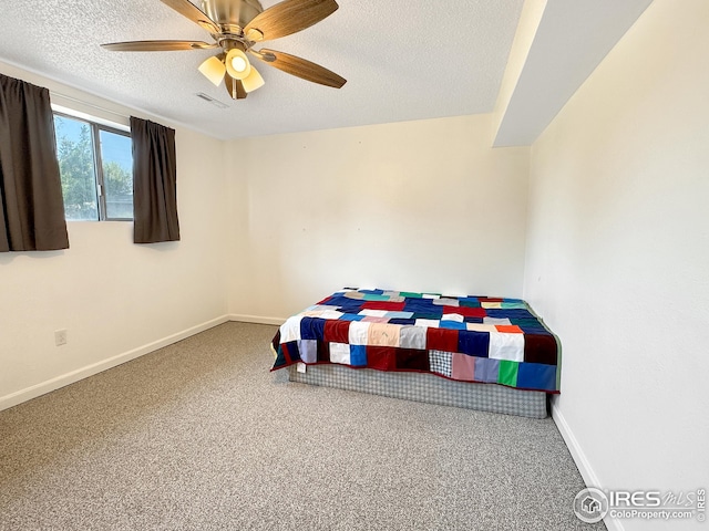 carpeted bedroom featuring ceiling fan and a textured ceiling