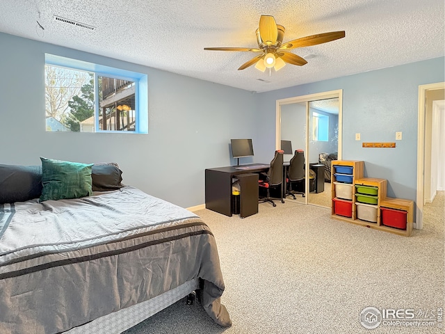 carpeted bedroom featuring ceiling fan, a textured ceiling, and a closet