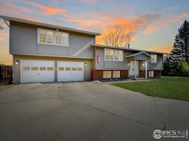 split foyer home featuring a lawn and a garage