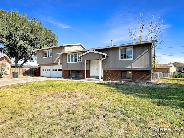 split foyer home featuring a front lawn and a garage