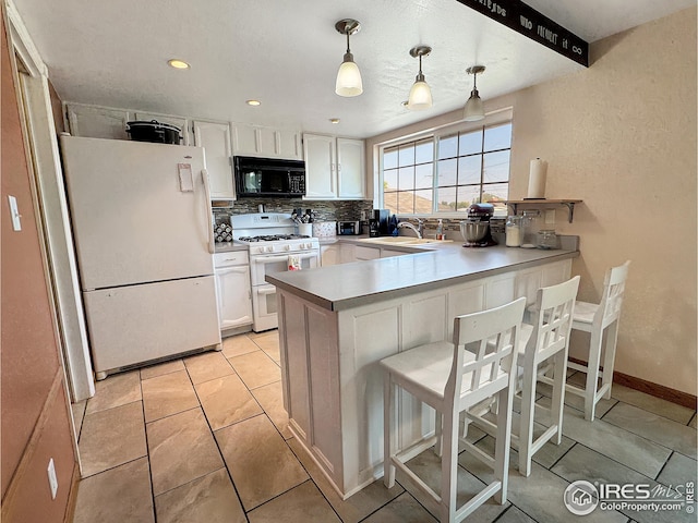 kitchen with white appliances, white cabinets, and kitchen peninsula