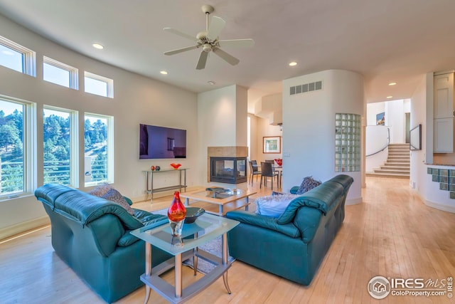 living area featuring visible vents, ceiling fan, light wood-style floors, recessed lighting, and stairs