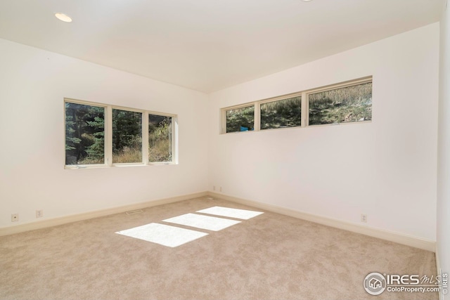 carpeted empty room with baseboards and recessed lighting