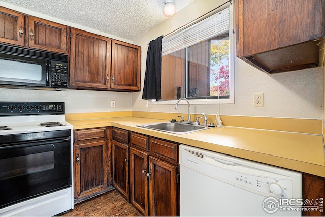 kitchen with white appliances, sink, and a textured ceiling