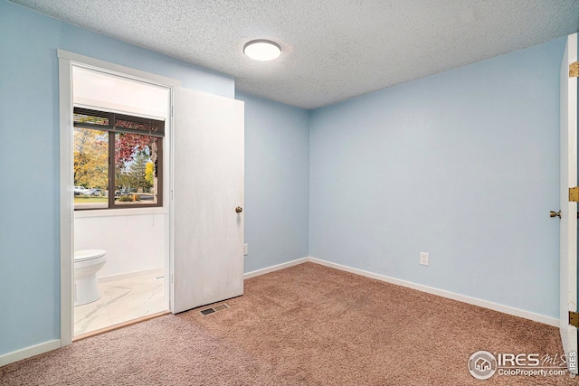 carpeted spare room featuring a textured ceiling