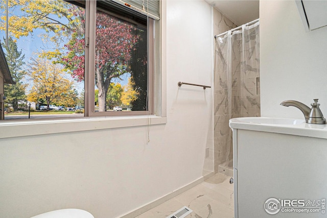 bathroom featuring sink, toilet, and curtained shower