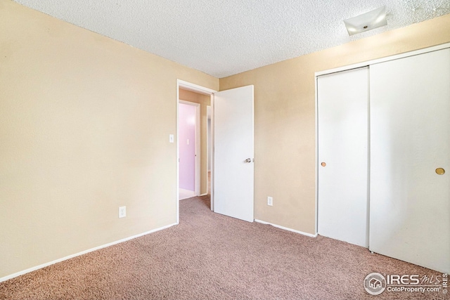 unfurnished bedroom featuring a textured ceiling, a closet, and carpet flooring