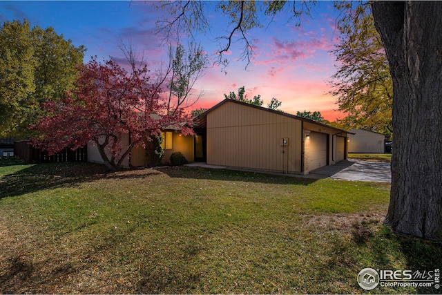 exterior space with a garage and a lawn