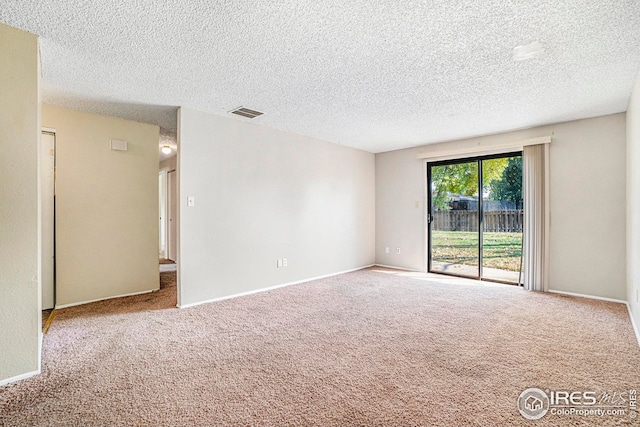 carpeted empty room with a textured ceiling