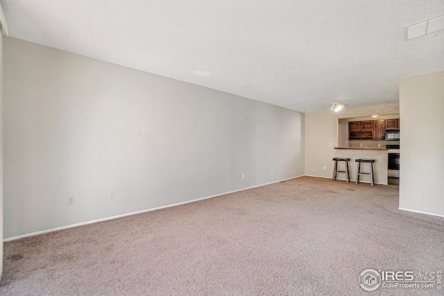 unfurnished living room featuring light colored carpet and a textured ceiling