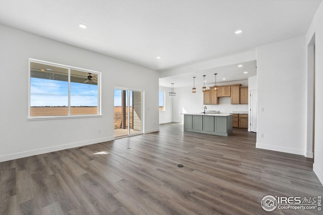 unfurnished living room with recessed lighting, dark wood-style floors, and baseboards