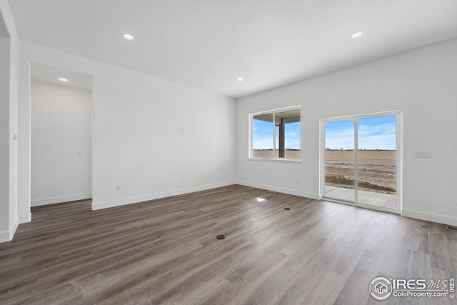 empty room with recessed lighting, baseboards, and wood finished floors