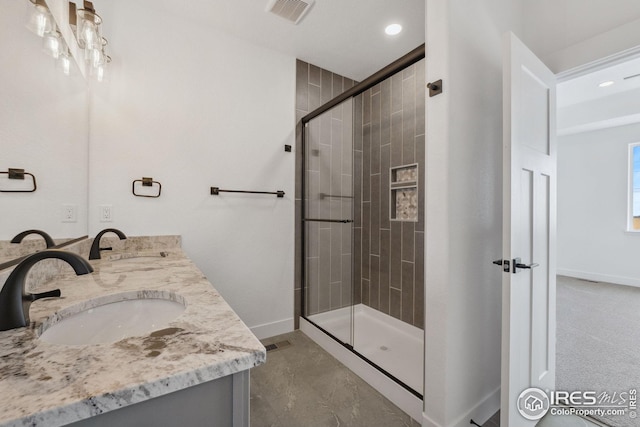 full bathroom with a sink, visible vents, baseboards, and a shower stall