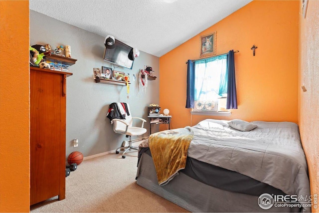 bedroom featuring vaulted ceiling, carpet, and a textured ceiling