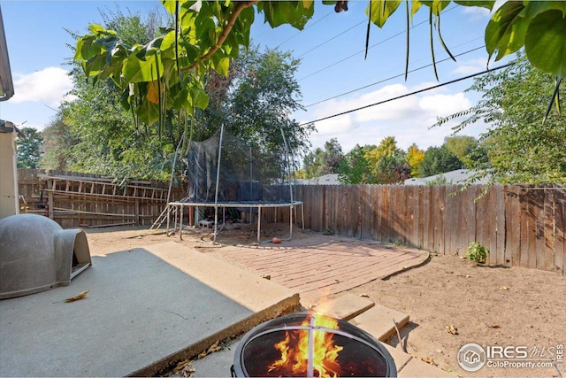 exterior space featuring a fire pit and a trampoline