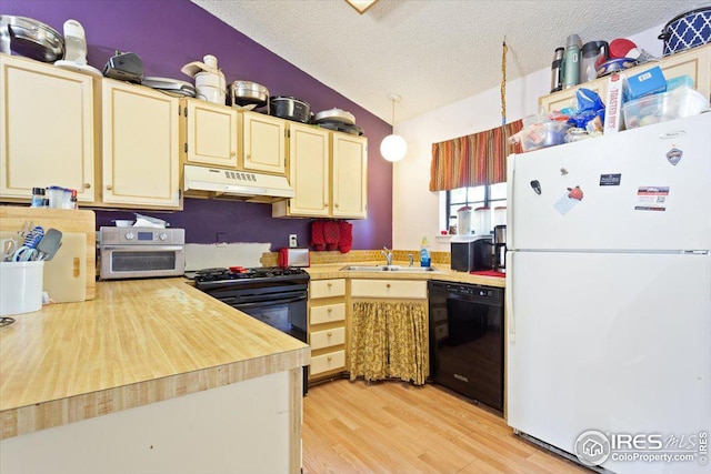 kitchen with sink, a textured ceiling, light hardwood / wood-style flooring, black appliances, and vaulted ceiling