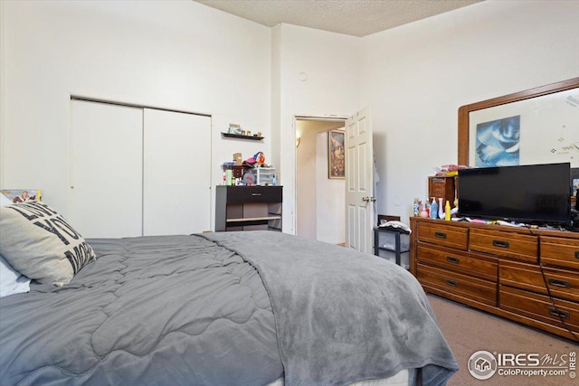 bedroom featuring a closet, a textured ceiling, and light carpet