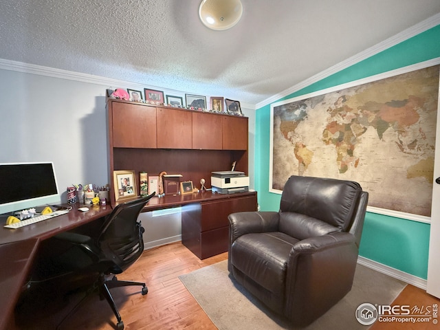 office space featuring lofted ceiling, light wood-style floors, ornamental molding, and a textured ceiling