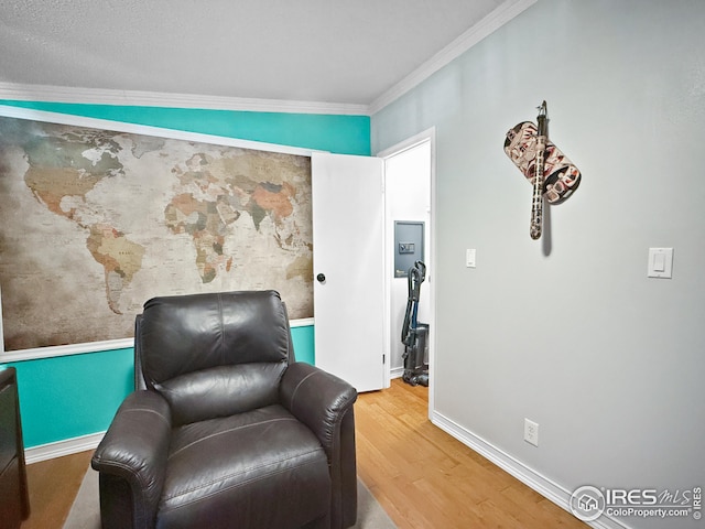 living area with ornamental molding, wood finished floors, and baseboards