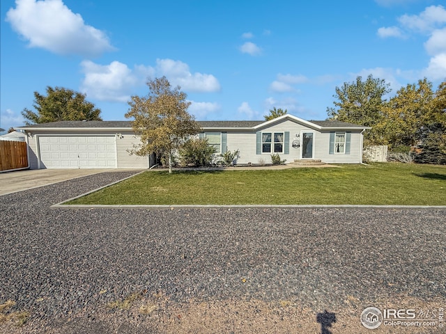 view of front of house with driveway, a garage, fence, and a front lawn