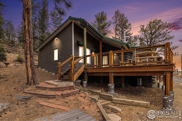 back house at dusk with a wooden deck