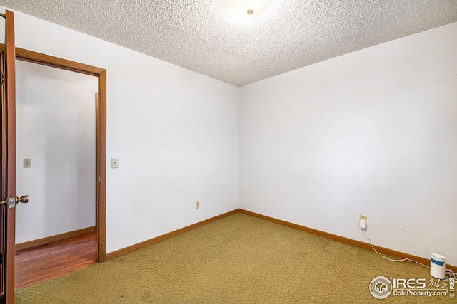 spare room with carpet floors and a textured ceiling