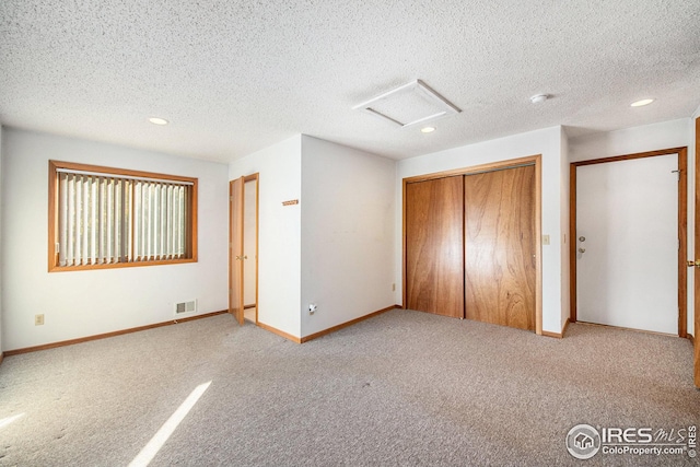 unfurnished bedroom with light carpet and a textured ceiling