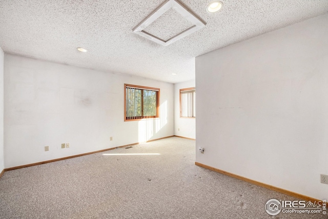 spare room with light carpet and a textured ceiling