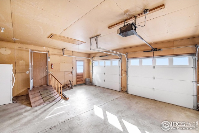 garage with white refrigerator and a garage door opener