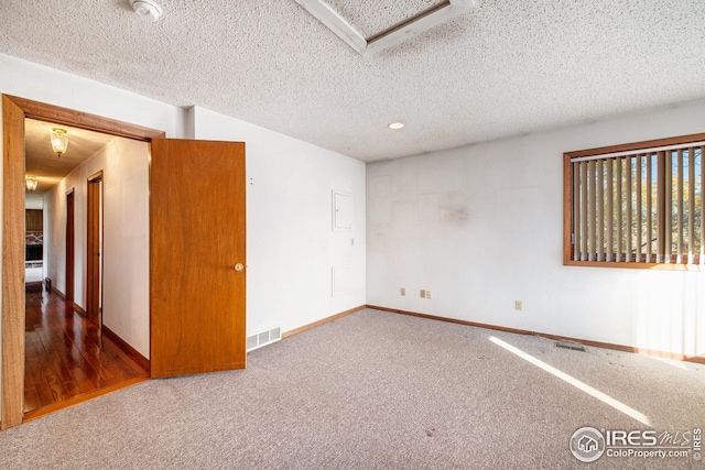 carpeted spare room with a textured ceiling